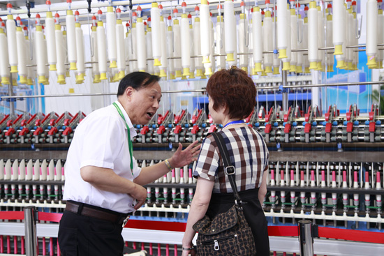 中国棉纺织协会会长朱北娜参观同和公司听取崔桂生董事长介绍紧密纺细纱机
